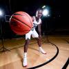 CU Boulder student athlete McKinley Wright holds a basketball on the court. 
