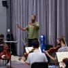  Kedrick Armstrong, a music+ scholarship recipient, conducts a group of musicians on strings.