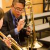 Middle School Ensemble participants with trombones reviewing music