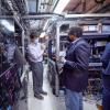 U.S. Rep. Joe Neguse, right, tours the lab of physicist Jun Ye at JILA in December 2021.