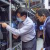 Jun Ye and Joe Neguse inspect equipment in the lab