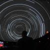 Instructor watches star trails while teaching a class in Fiske Planetarium