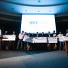 New Venture Challenge finalists pose with giant checks on stage