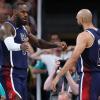 LeBron James and Derrick White interact on the basketball court, arms extended and facing each other.