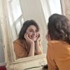 single person smiling at self in mirror