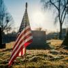 Tiny American flag in ground at cemetery