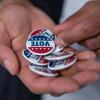 A person holding "Vote" buttons
