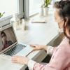 A person wearing a mask videoconferencing with someone