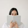 Person with a book in front of her face