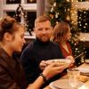 Friends and family gather at a table over the holidays
