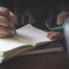 Person copying notes down into a notebook