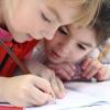 Two children coloring in a book