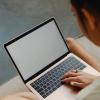 A person sits with a laptop in their lap. Photo by Karolina Grabowska from Pexels