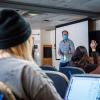 Students listen to lecturer while physically distancing