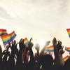 Silhouette of people holding Pride flags
