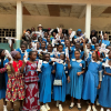 Women and girls in Cameroon excitedly holding biodegradable menstrual pads