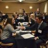 Student shakes hands with professional at summit