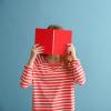 person covering face with red book