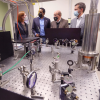 Margaret Murnane, U.S. Rep. Joe Neguse, Philip DiStefano and Todd Saliman inspect equipment in a lab