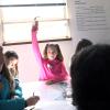 Young student raising her hand in rap lab