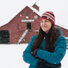 Rebecca Safran standing outside in the snow in front of a barn