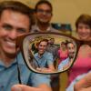 Bart Foster and Wil Srubar look through a pair of eyeglass lenses with graduate research assistants Sankar Ravichandran and Elizabeth Delesky standing behind them. 
