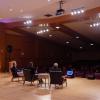 Panelists sit in chairs on stage facing audience members