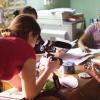 Assistant Professor Sandra Ristovska takes photo of a stack of CD-ROMs