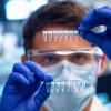 A researchers holds up a COVID-19 test
