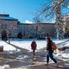Students walk across a snowy campus