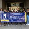 Students hold Health Sciences High & Middle College Schools of Opportunity banner