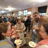 People mingle in a large conference hall.