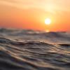 Ocean waves with orange sunset in background