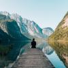 Person meditating by a lake