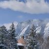 Snow-topped building on campus with Flatirons in the background