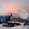 A radar dish mounted on the bed of a truck. 