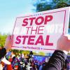 A protester holds a stop the steal sign