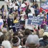 Demonstrators hold up signs at a Stop Abortion Bans rally