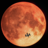 Artist's depiction of the Hubble Space Telescope passing in front of the moon during a total lunar eclipse.