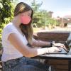 student working on laptop outside on campus