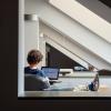 A person sits at a study table with a laptop.