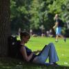 Student studying by tree.