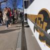 Students walk past Buff Bus