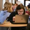 student works on laptop on campus