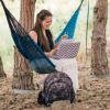 Student sits in hammock on campus while studying