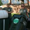 Two people rolling recycling bins on campus 