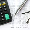 Calculator, pay stubs, pen and eye glasses