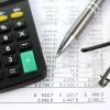 Calculator, pay stubs, pen and eye glasses