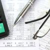 Calculator, pay stubs, pen and eye glasses