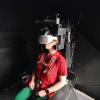 Woman sits strapped into heavy-duty chair wearing a virtual reality headset